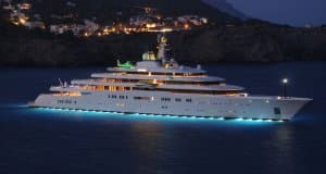 Eclipse superyacht illuminated at night, showcasing its luxurious design and marine engineering, relevant to yacht ownership and electrical systems.