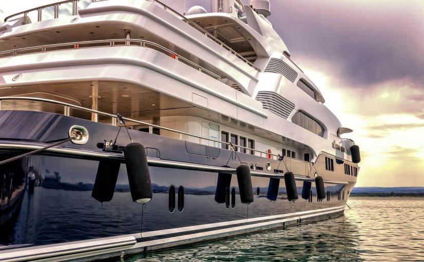 Luxury yacht docked in calm waters, showcasing sleek design and modern amenities, ideal for summer cruising in destinations like French Polynesia.