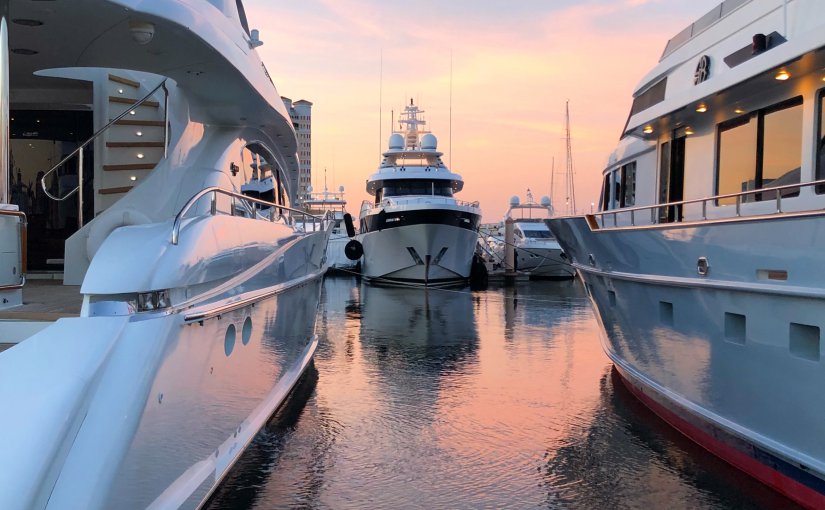 Luxury yachts docked in a marina at sunset, highlighting Fort Lauderdale's status as the "Yachting Capital of the World."