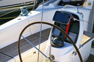 Boat cockpit featuring a steering wheel, navigation equipment, and a digital display, emphasizing marine electrical systems and onboard upgrades.