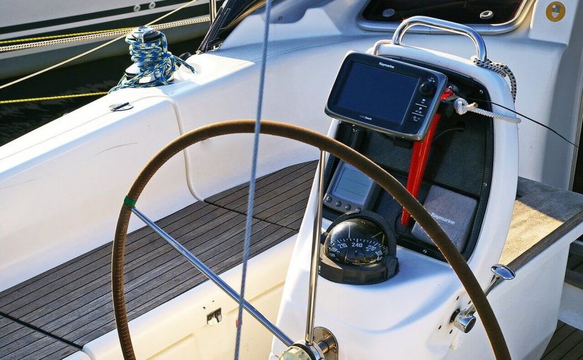 Boat cockpit with steering wheel, navigation display, and electronic instruments, illustrating marine technology upgrades for enhanced onboard comfort and connectivity.