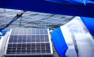 Solar panel on a yacht deck, showcasing marine solar energy integration with blue canvas and water background.