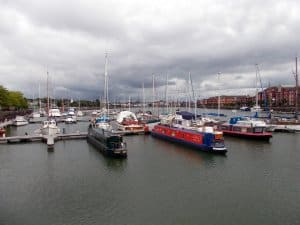 Marina scene with various yachts and boats docked, cloudy sky reflecting potential storm conditions, emphasizing the importance of marine electrical services for yacht safety and maintenance.