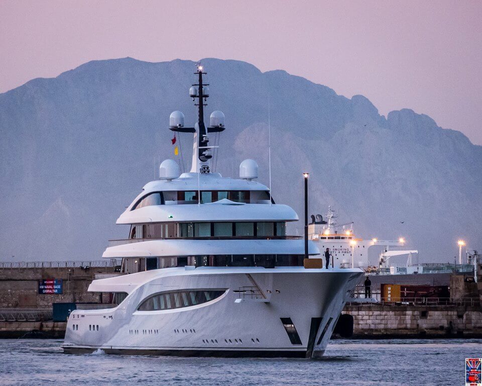 Superyacht FAITH navigating in harbor near mountains, showcasing luxury yacht design and features relevant to yacht survey discussions.
