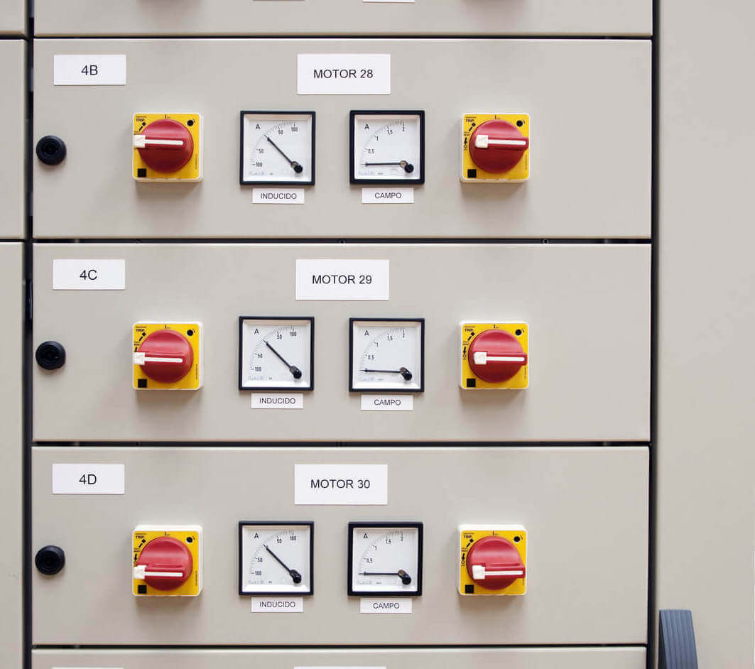 Electrical cubicle panel board displaying motor controls and gauges for yacht electrical systems, featuring labeled switches and meters indicating electrical capacity and performance.