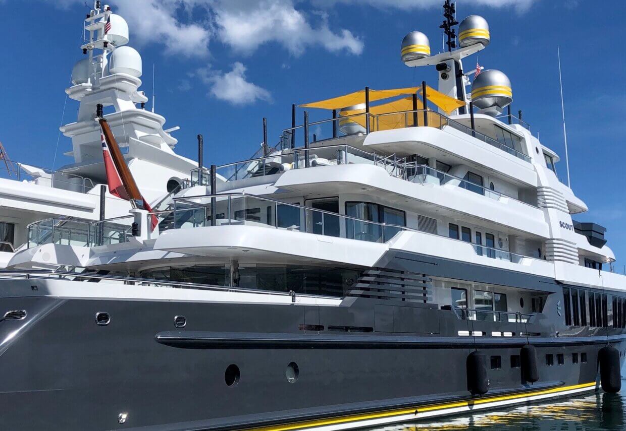 Luxury yacht with modern design and multiple decks, featuring radar equipment, a yellow awning, and a sleek gray hull, reflecting Tess Electrical's yacht refit services.