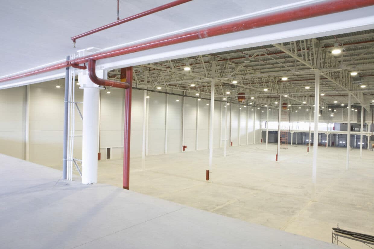 Large Empty Warehouse With Red Piping