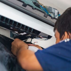 Technician performing marine electrical service on yacht equipment, showcasing expertise in yacht services at Tess LLC in South Florida.