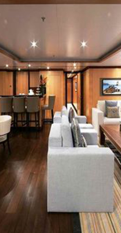 Modern yacht interior showcasing elegant seating, polished wooden floors, and ambient lighting, highlighting Tess LLC's marine electrical and lighting expertise.