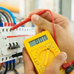 Hands using a multimeter to test electrical connections in a marine electrical system, emphasizing expertise in yacht electrical services and safety protocols.