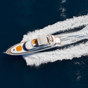 Luxury yacht cruising through deep blue waters, showcasing sleek design and wake trails, emphasizing onboard space and comfort for yacht owners.