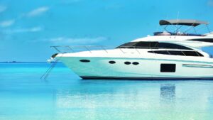 Luxury yacht anchored in clear turquoise waters, emphasizing marine maintenance and electrical services for yacht owners.