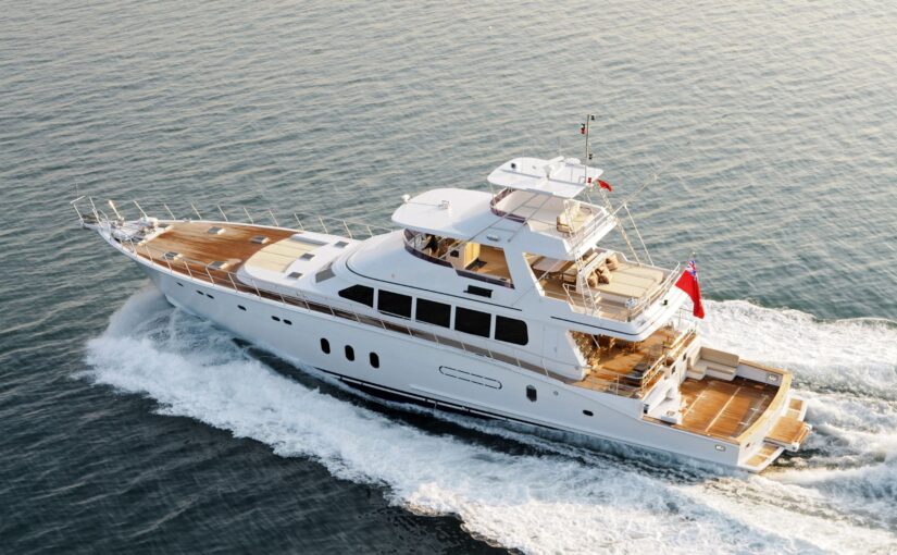 Luxury yacht cruising on calm waters, showcasing sleek design and wooden deck, relevant to yacht maintenance and ownership responsibilities.