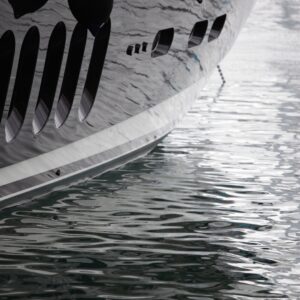 Yacht hull partially submerged in water, highlighting the importance of regular maintenance to prevent damage and ensure seaworthiness.