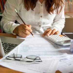 Yacht security alarm system components on a desk, featuring a calculator, paperwork, and a laptop, emphasizing the importance of reliable marine security solutions.