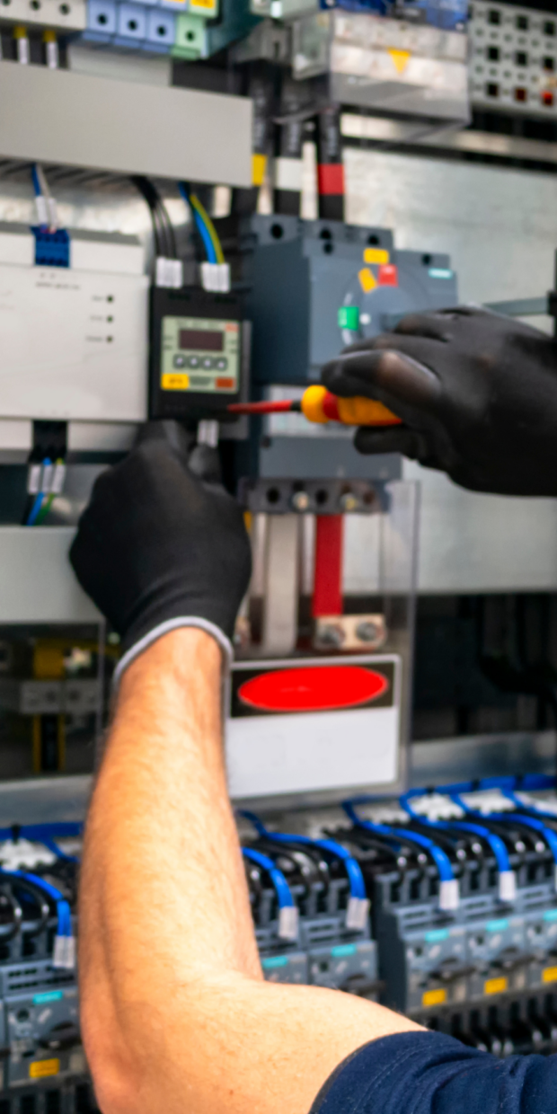 Electrician working on yacht electrical panel with tools, showcasing marine electrical service expertise by TESS LLC in Dade County.