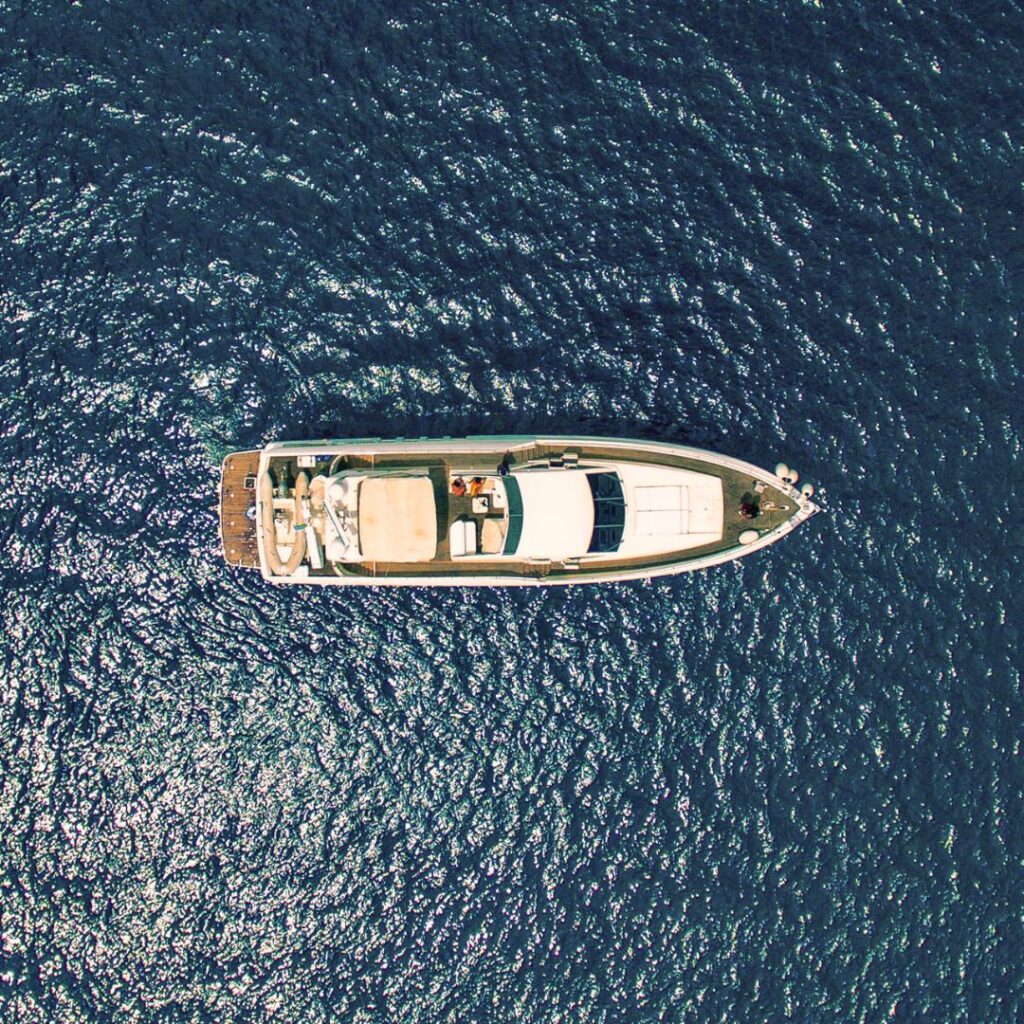 Aerial view of a luxury yacht on calm blue waters, highlighting the importance of yacht alarm systems for security and peace of mind.