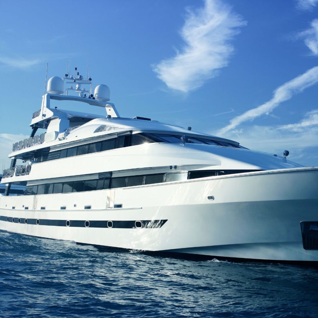 Luxury yacht navigating calm waters under a clear blue sky, showcasing advanced marine design and technology relevant to Tess LLC's marine power management solutions.