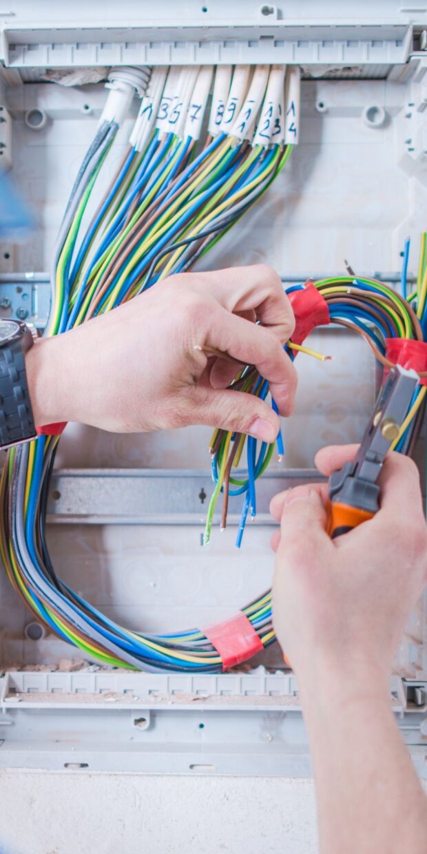 2 yacht electrical services in palm beach county Hands working on yacht electrical wiring, showcasing colorful wires and tools, emphasizing quality workmanship and expertise in marine electrical services.