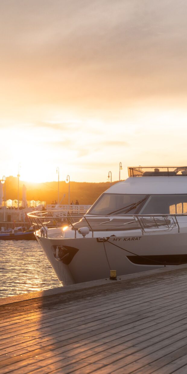 Yacht named "MY KARAT" docked at sunset in a marina, highlighting electrical systems and marine services context.