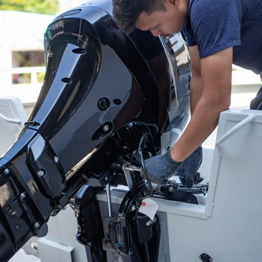 Technician performing maintenance on a yacht's outboard motor, showcasing expertise in marine engineering and yacht installations.