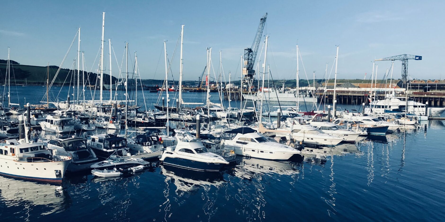 Marina filled with various yachts and boats in calm waters, showcasing marine electrical services and yacht maintenance in Dade County, Florida.