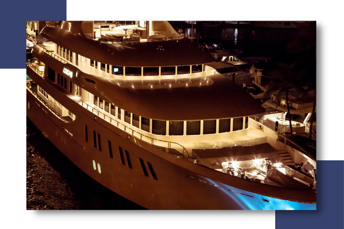Luxury yacht illuminated at night, showcasing elegant lighting and inviting ambiance, emphasizing the importance of reliable electrical systems for guest comfort and safety in marine settings.