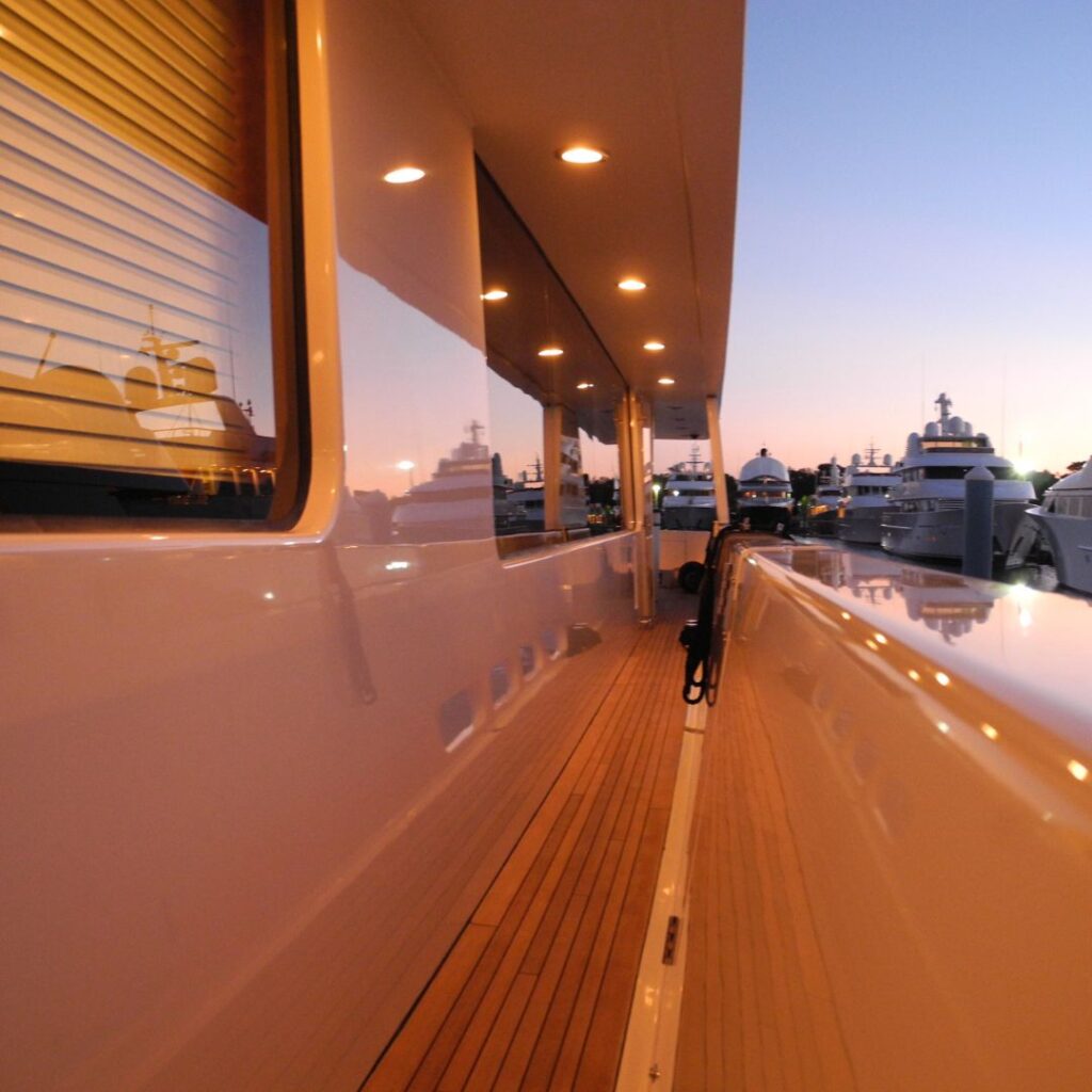 Yacht deck at sunset showcasing polished surfaces and LED lighting, highlighting marine electrical upgrades and aesthetic enhancements in a marina setting.