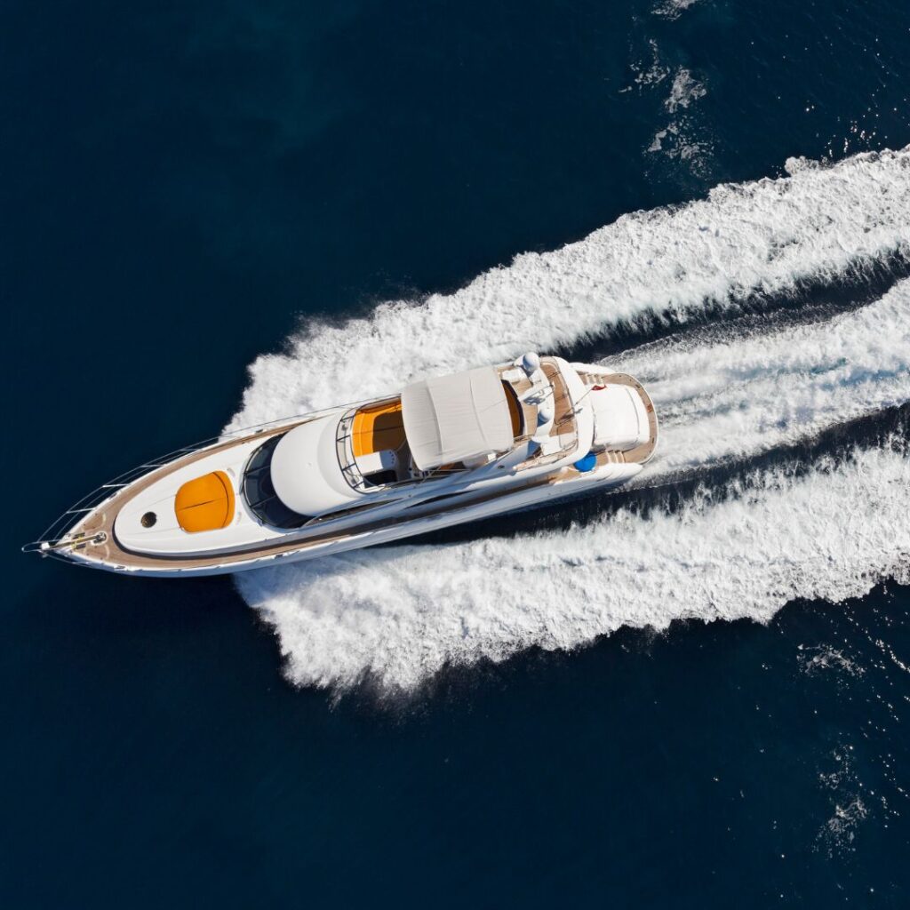 Luxury yacht cruising on blue waters, showcasing upgraded power system and performance enhancements, with visible wake and sleek design.