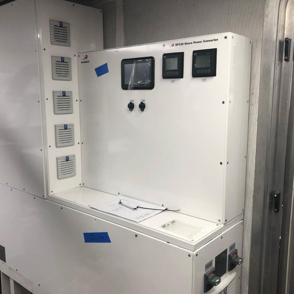 Yacht shore power converter system by Magnus, featuring control panels and connection points, enhancing energy efficiency and flexibility for marine power supply.