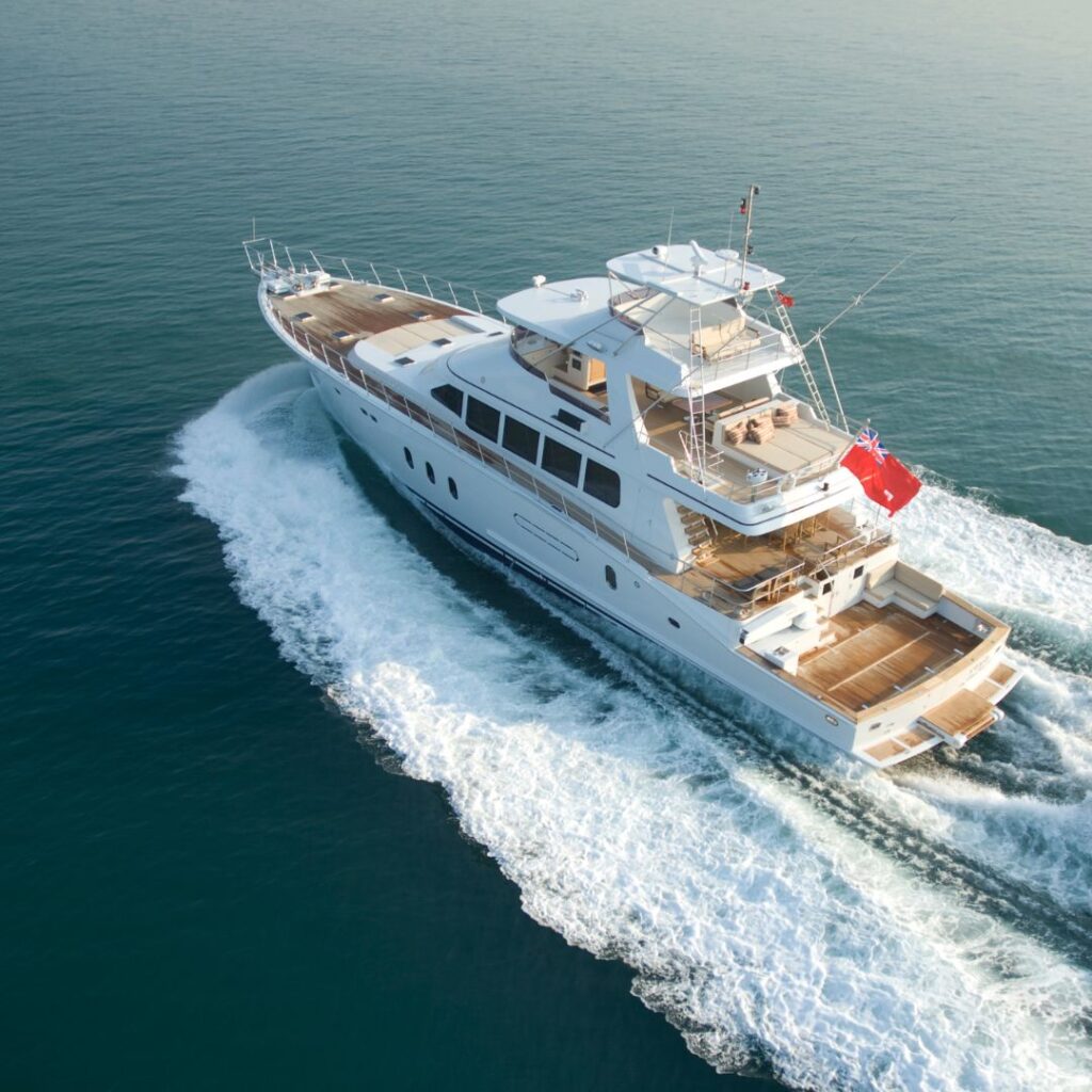 Luxury yacht cruising on calm waters, showcasing sleek design and spacious deck, representing TESS LLC's marine services for yacht power optimization.