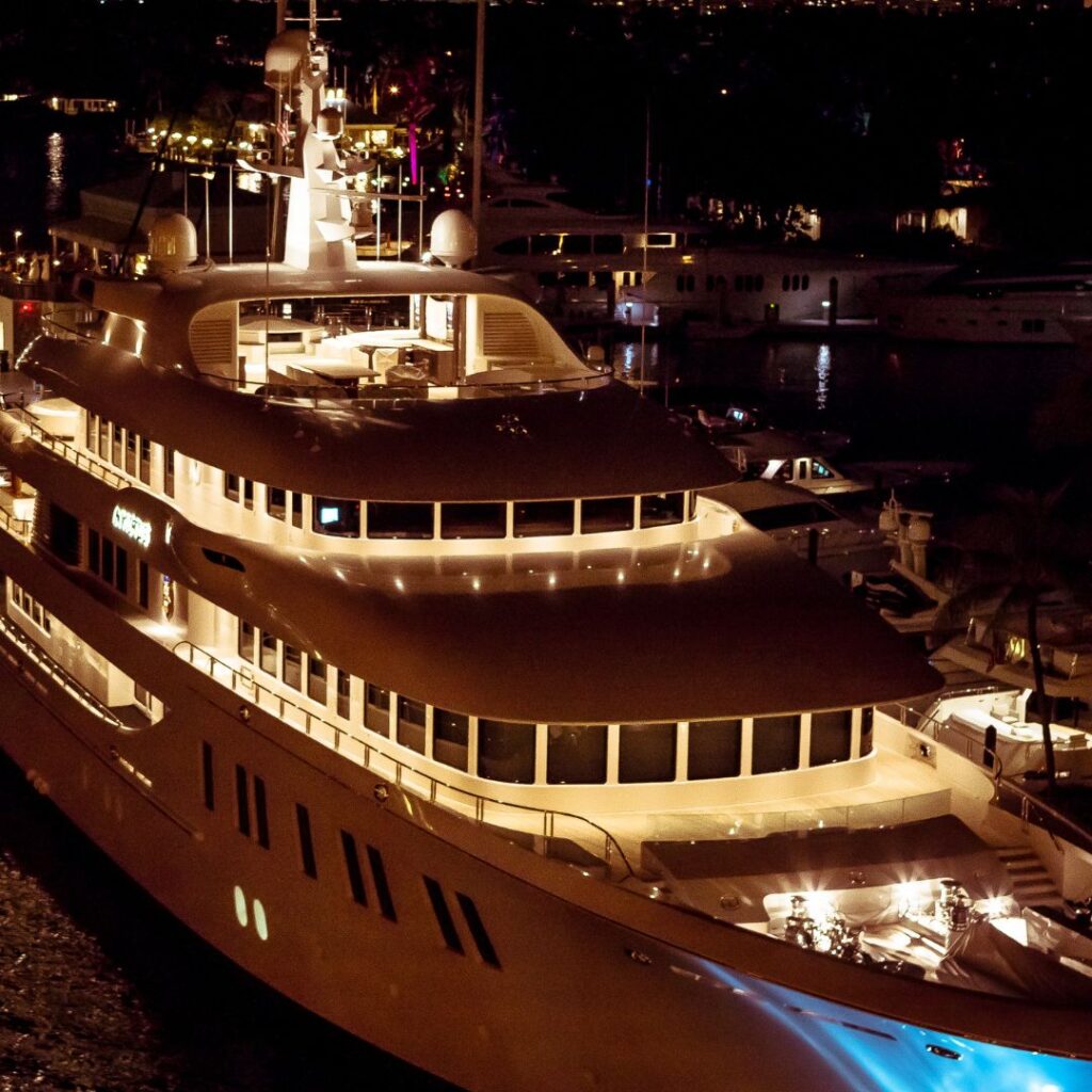 Luxury yacht illuminated at night, showcasing modern design and spacious deck, relevant to selecting power management systems for optimal yacht performance and efficiency.