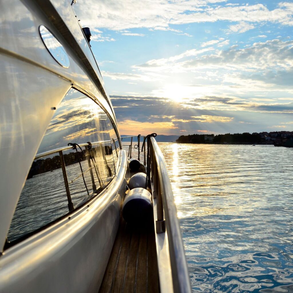 Yacht bow reflecting sunset over calm waters, emphasizing marine power management and onboard electronics integration.
