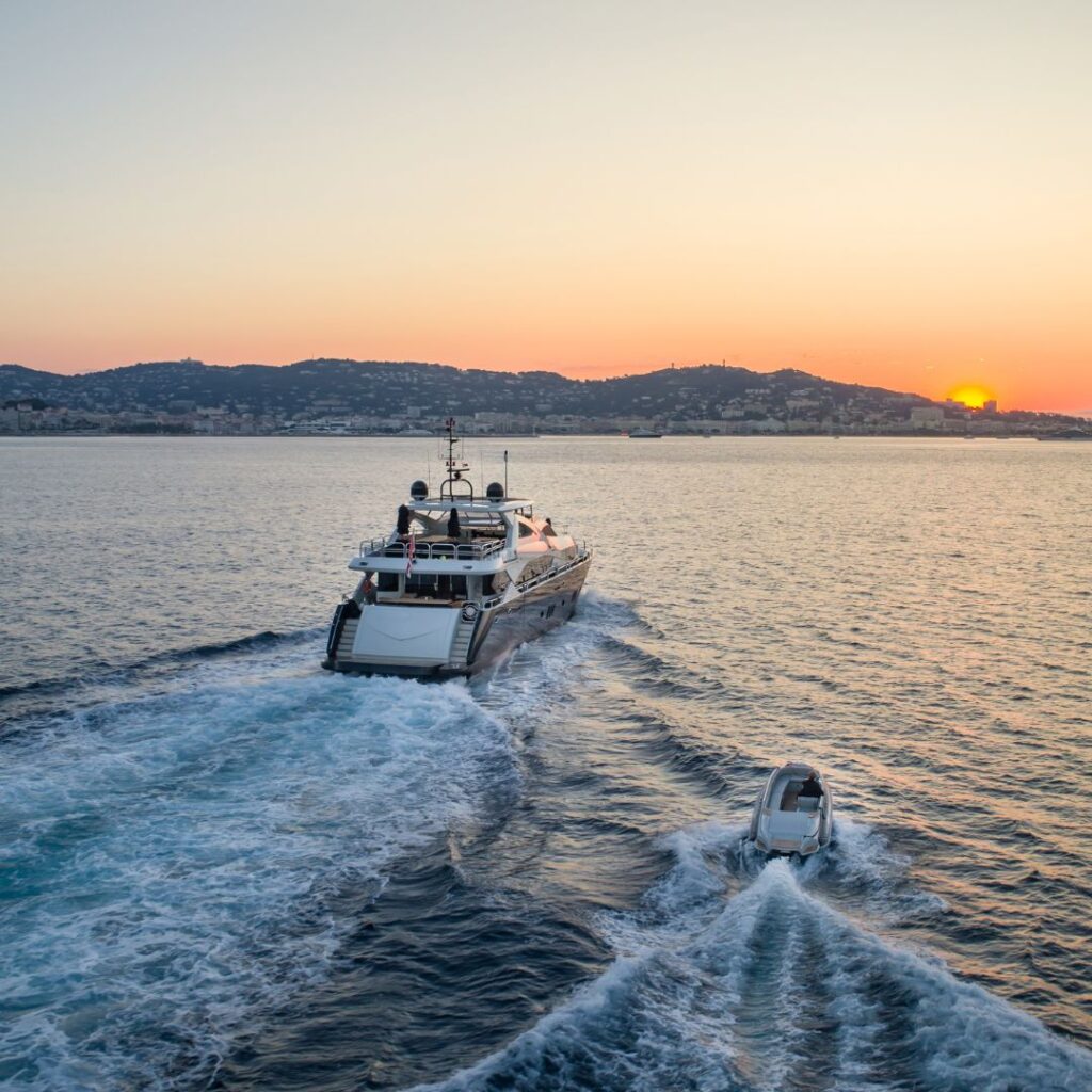 Luxury yacht navigating calm waters at sunset, showcasing marine power management and onboard electronics integration.