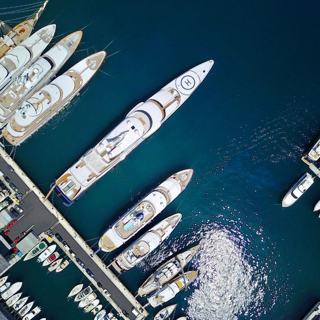 Aerial view of luxury yachts docked in marina, showcasing marine electrical systems and yacht security essentials for TESS LLC's services.