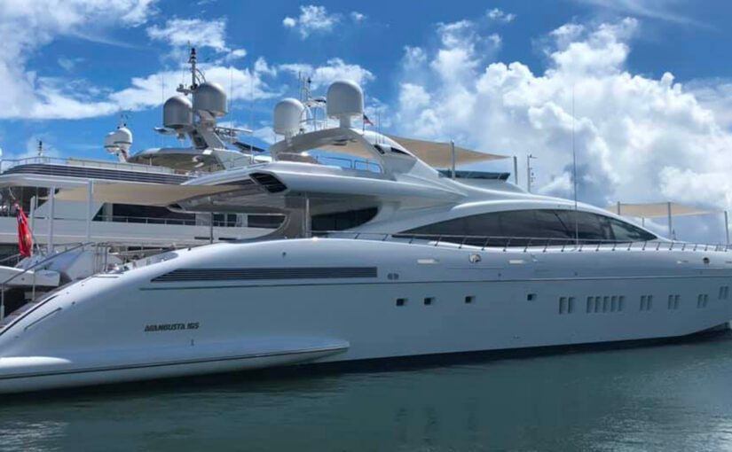 Luxury yacht docked at marina, showcasing sleek design and advanced technology, relevant to yacht shore power solutions and marine electrical services.