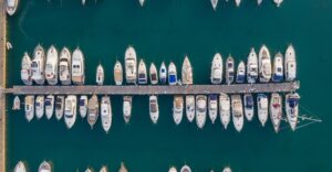 Aerial view of a marina with multiple yachts and boats docked along a wooden pier, highlighting marine electrical service opportunities in Fort Lauderdale.