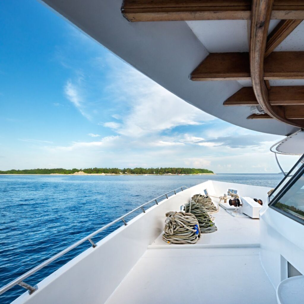 View from the deck of a yacht overlooking calm waters and a distant shoreline, emphasizing the serene environment for yacht owners.
