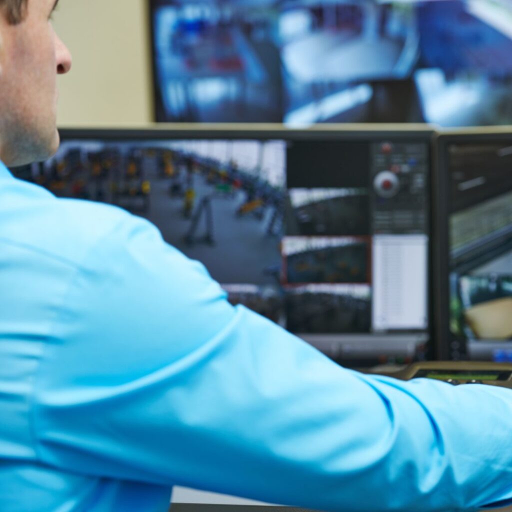 Person monitoring yacht electrical systems on multiple screens, showcasing advanced remote monitoring technology for efficient yacht operation.
