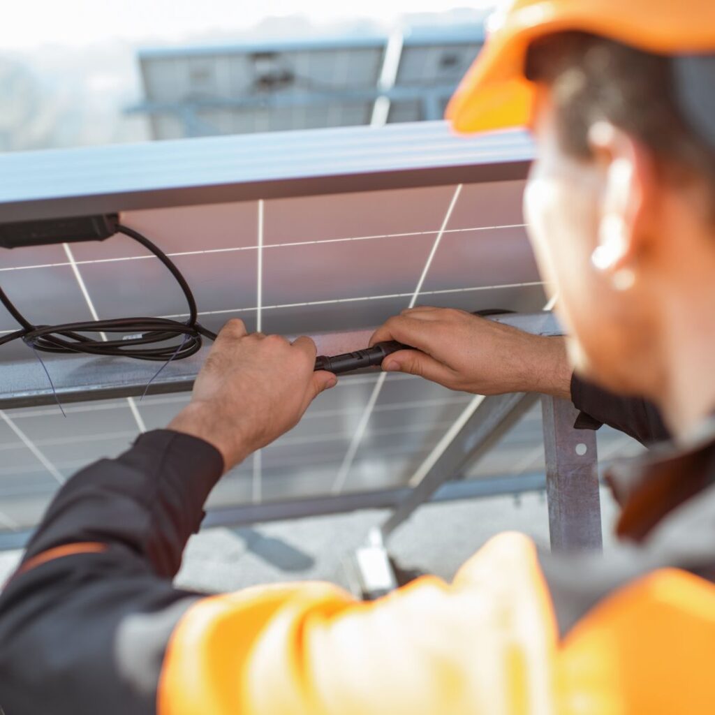 Technician installing solar panel connections, emphasizing renewable energy integration for yachts at TESS LLC.