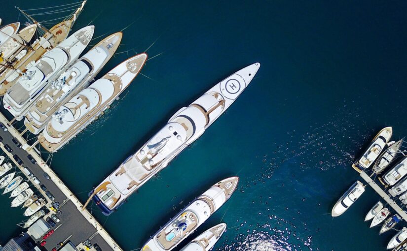 Aerial view of luxury yachts docked at a marina, showcasing innovative marine electrical technology and design in the yacht industry.