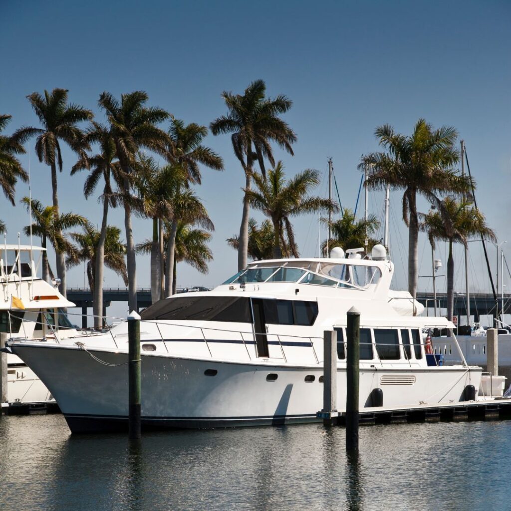 Yacht docked in Fort Lauderdale with palm trees and marina in the background, representing TESS Electrical LLC's yacht electrical installation services.