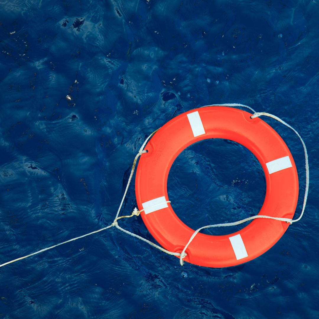 Lifebuoy floating in deep blue water, symbolizing safety and emergency preparedness for yacht owners in Savannah.