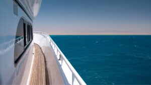 View from a yacht's deck showcasing vibrant blue waters and a distant coastline, emphasizing the marine experience in Savannah for yacht maintenance and services.