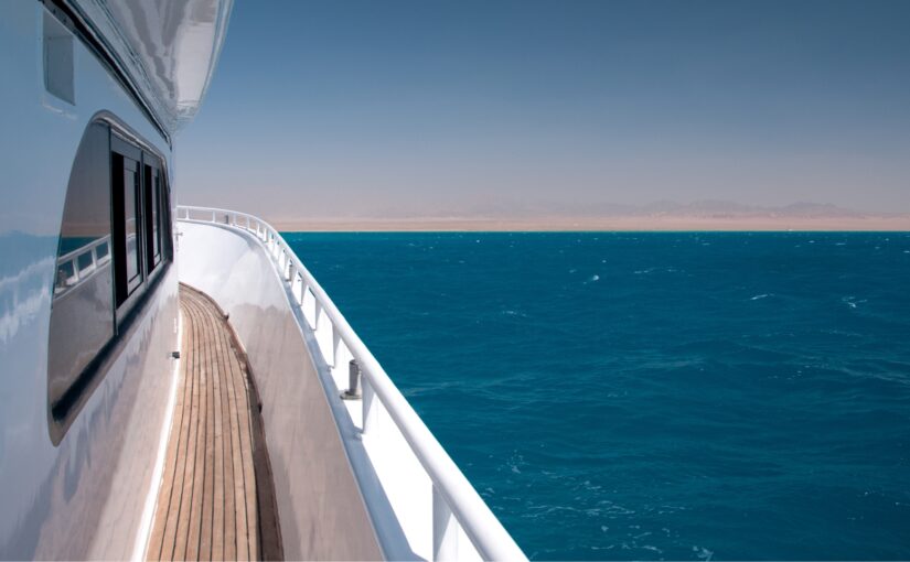Yacht's deck overlooking vibrant blue waters and distant shoreline, reflecting Safe Harbor Savannah Yacht Center's focus on marine services and yacht maintenance.