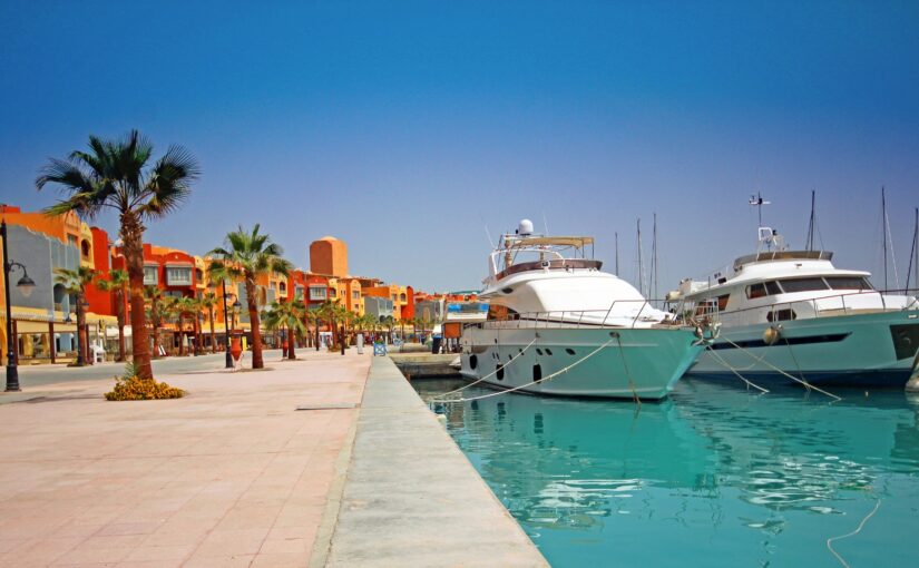 Yachts docked along a vibrant marina waterfront in Savannah, showcasing luxury vessels and colorful buildings, emphasizing marine electrical services and Magnus Shore Power Converters.