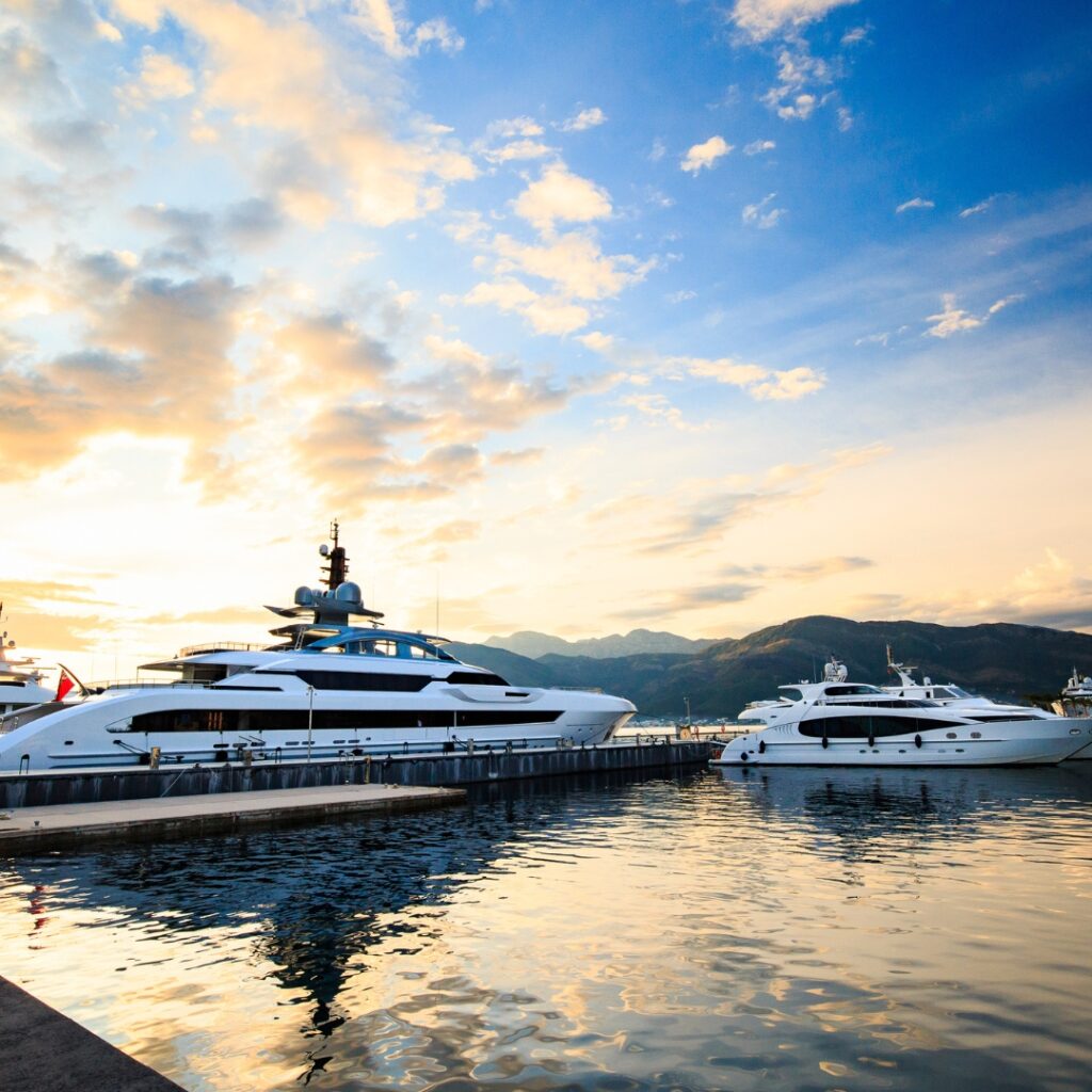 Yachts docked at a marina during sunset, reflecting on calm waters, symbolizing luxury yacht maintenance services at Safe Harbor Savannah Yacht Center.