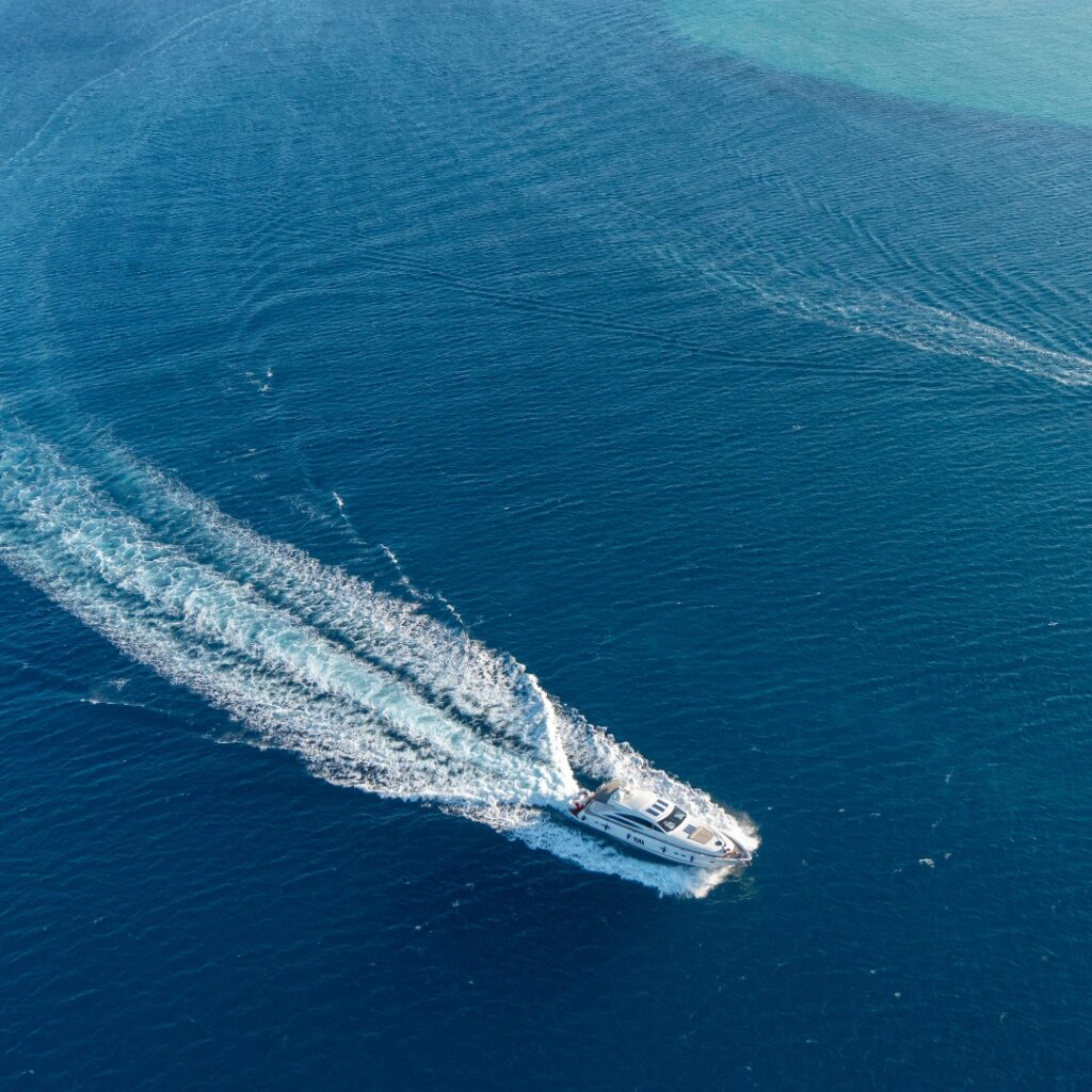 Luxury yacht navigating through deep blue waters, showcasing maritime efficiency and safety, relevant to Magnus Shore Converters' power supply solutions.