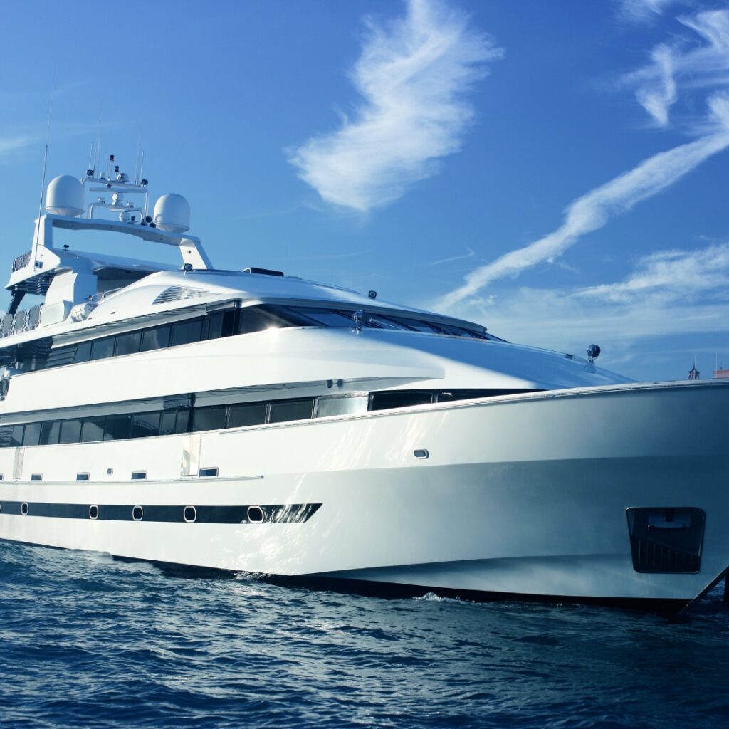 Luxury yacht cruising on calm waters under a clear blue sky, highlighting advanced marine design and technology relevant to Magnus Shore Converters for enhanced vessel performance.