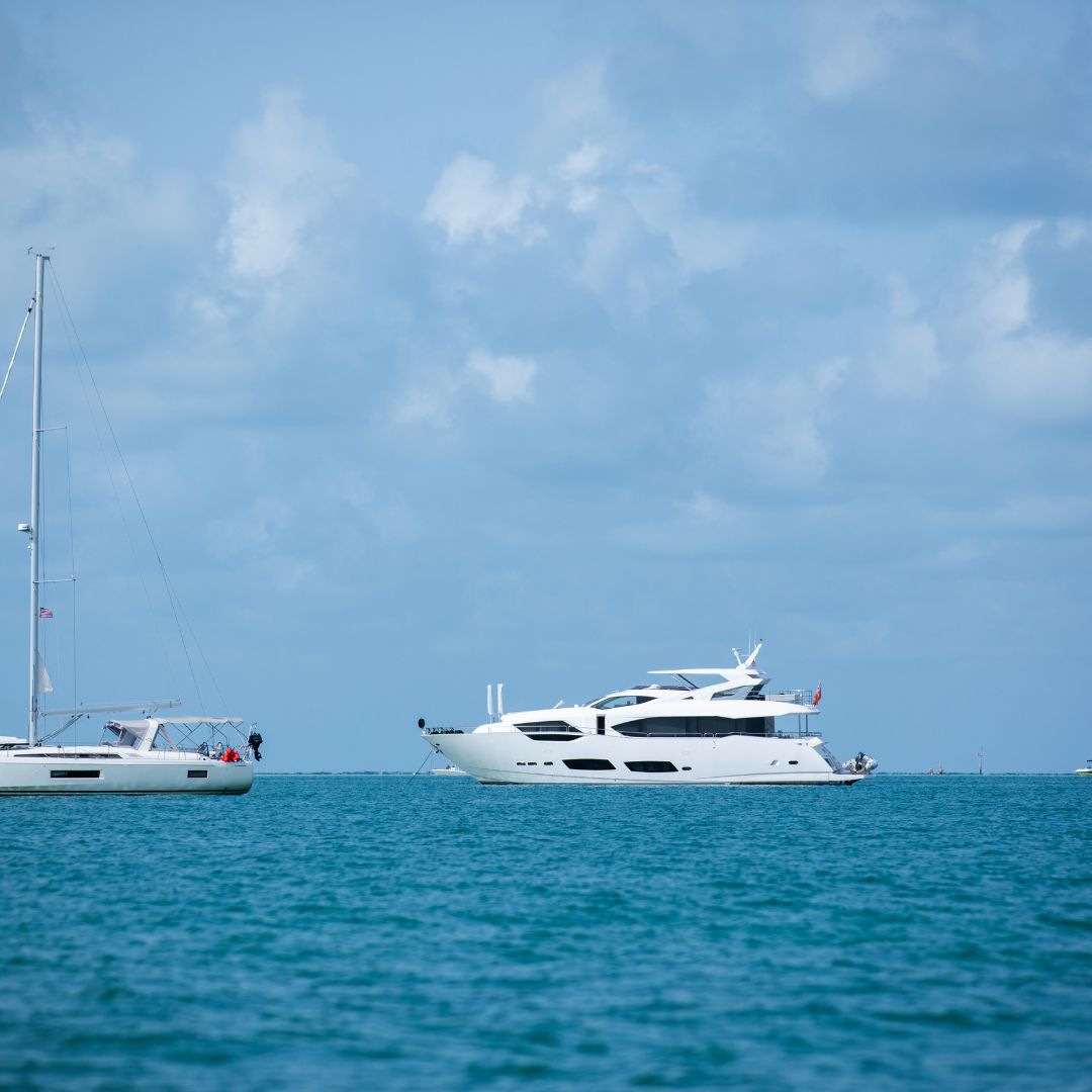 Luxury yacht cruising on the Amalfi Coast, showcasing advanced electrical systems and marine technology, with a second yacht in the background against a clear blue sky.